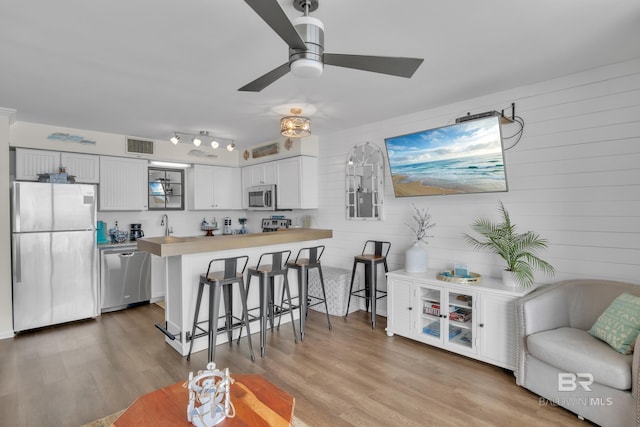 24522 Perdido Beach Blvd Unit 3705, Orange Beach, AL 36561 - kitchen featuring a peninsula, a ceiling fan, visible vents, a kitchen bar, and appliances with stainless steel finishes