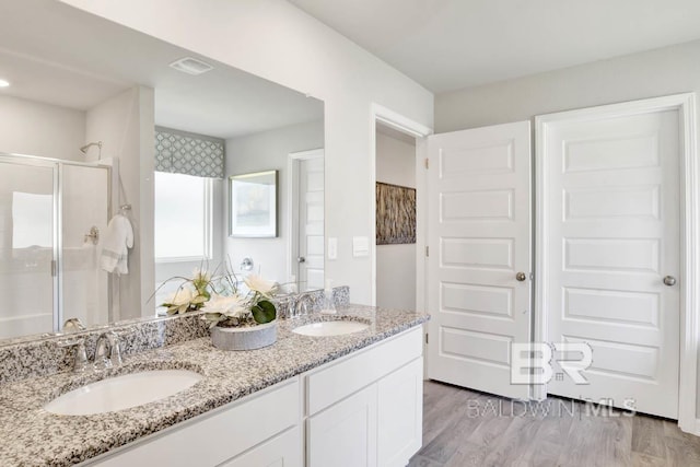 bathroom featuring vanity, an enclosed shower, and hardwood / wood-style floors