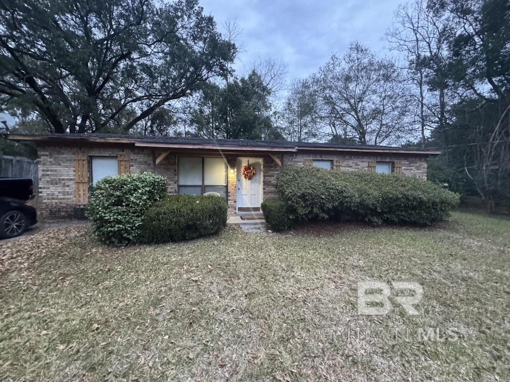 ranch-style home with brick siding and a front yard