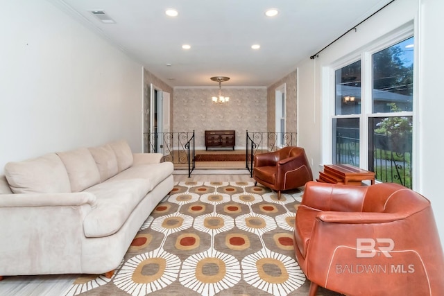 living room featuring light hardwood / wood-style floors, a notable chandelier, and ornamental molding