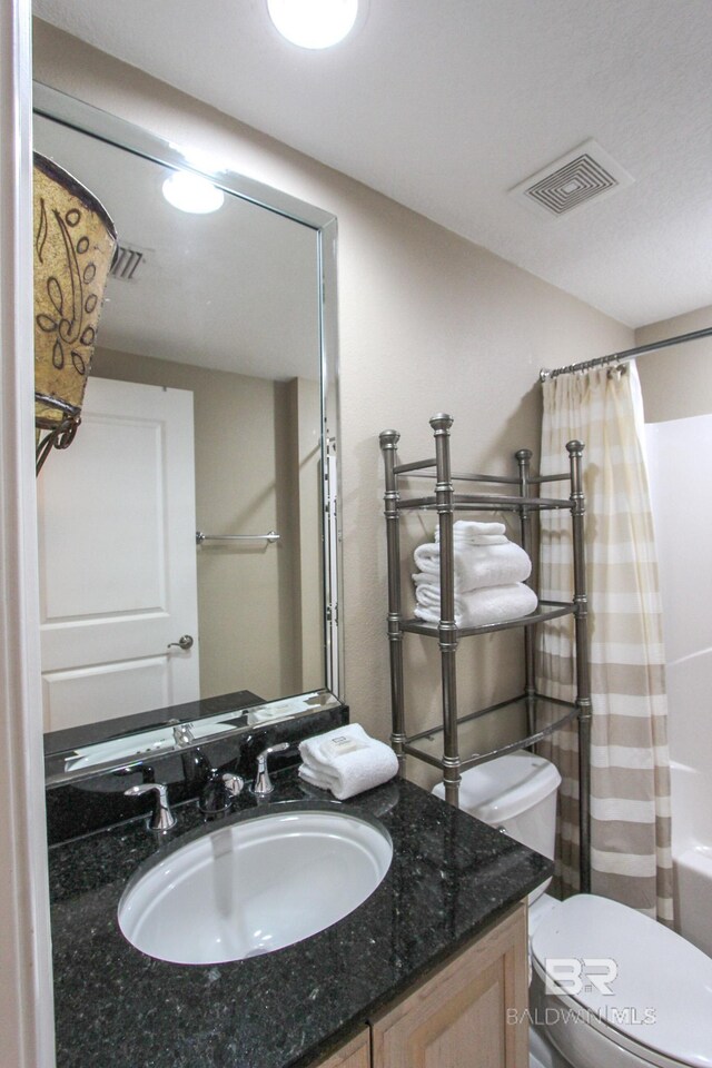 full bathroom with shower / bath combo with shower curtain, vanity, and toilet