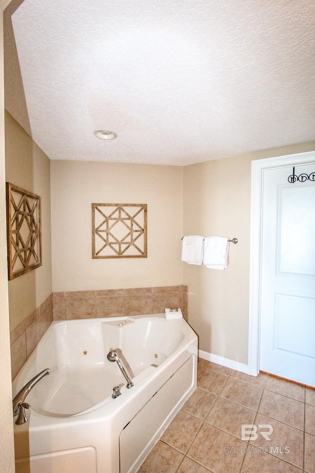 bathroom with a bathtub, a textured ceiling, and tile patterned flooring