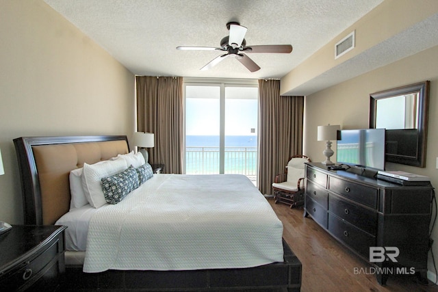 bedroom featuring ceiling fan, access to exterior, dark wood-type flooring, and multiple windows