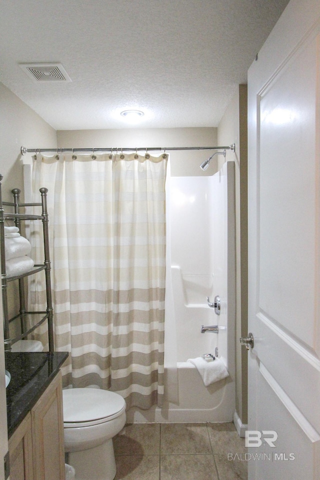 full bathroom featuring vanity, a textured ceiling, tile patterned flooring, shower / tub combo with curtain, and toilet