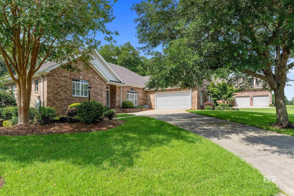 view of front of property featuring concrete driveway, a front lawn, brick siding, and a garage
