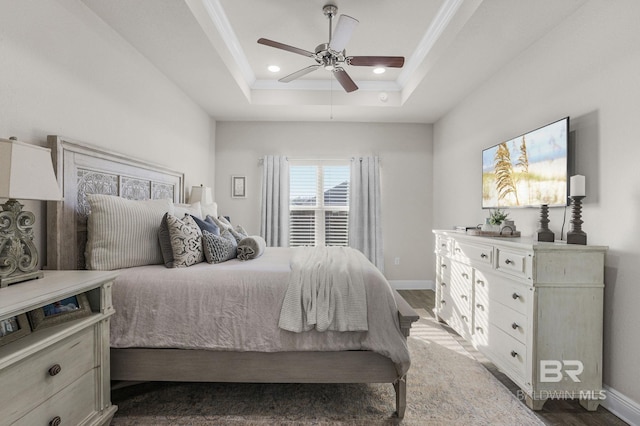 bedroom with a raised ceiling, ornamental molding, ceiling fan, and dark hardwood / wood-style flooring