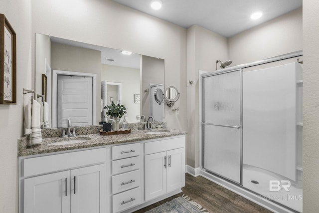 bathroom featuring hardwood / wood-style flooring, vanity, and a shower with shower door