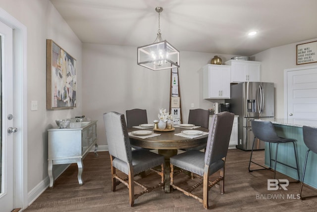 dining space with an inviting chandelier and dark hardwood / wood-style flooring