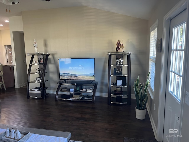 living room featuring dark hardwood / wood-style flooring and vaulted ceiling