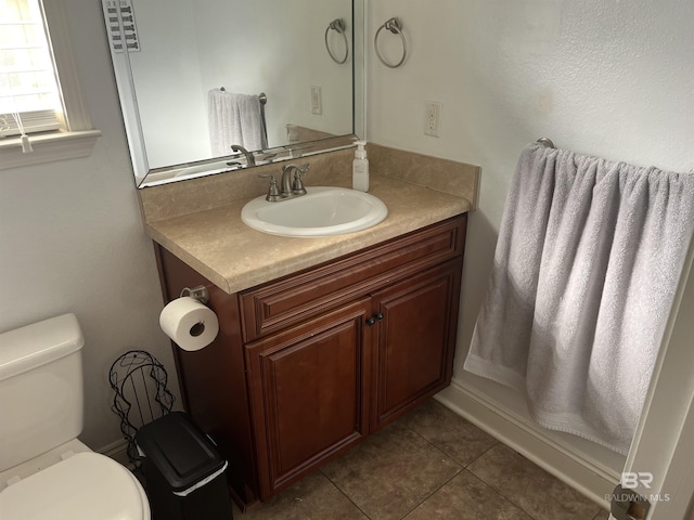 bathroom featuring tile patterned flooring, vanity, and toilet