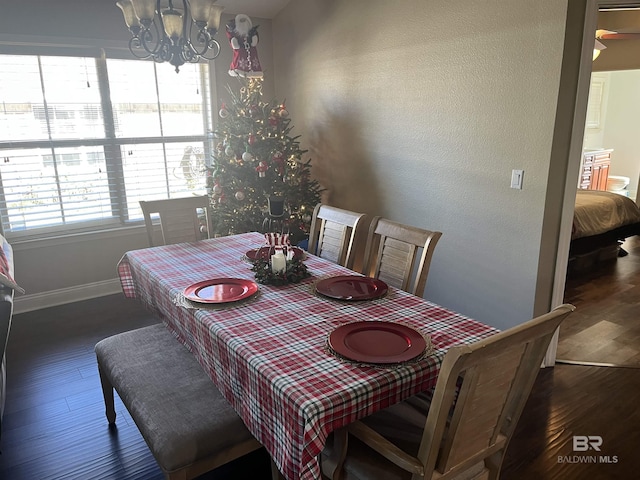 dining room with dark hardwood / wood-style flooring and a notable chandelier