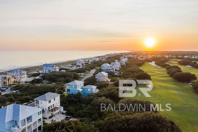 aerial view at dusk featuring a water view