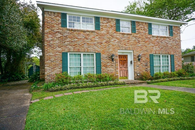 colonial home with brick siding and a front lawn