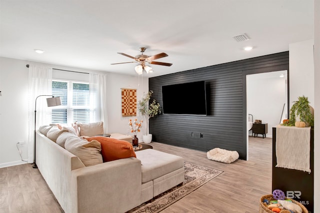 living room featuring ceiling fan and light hardwood / wood-style floors