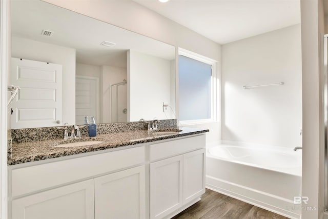 bathroom with hardwood / wood-style floors, vanity, and separate shower and tub