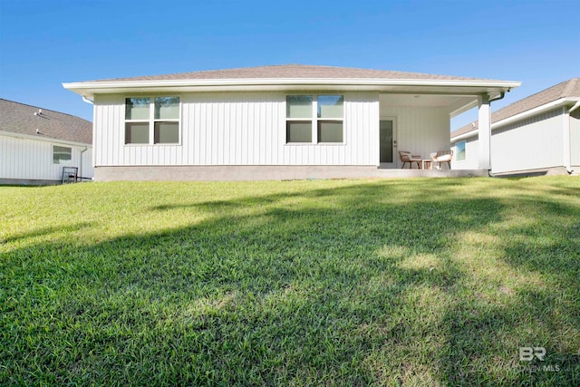 rear view of property featuring a lawn