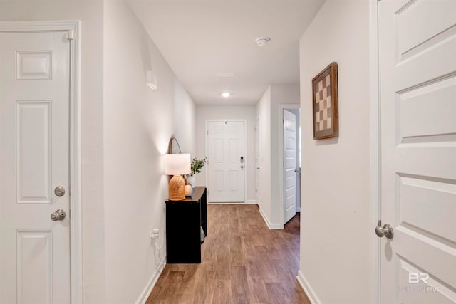 hallway with hardwood / wood-style flooring