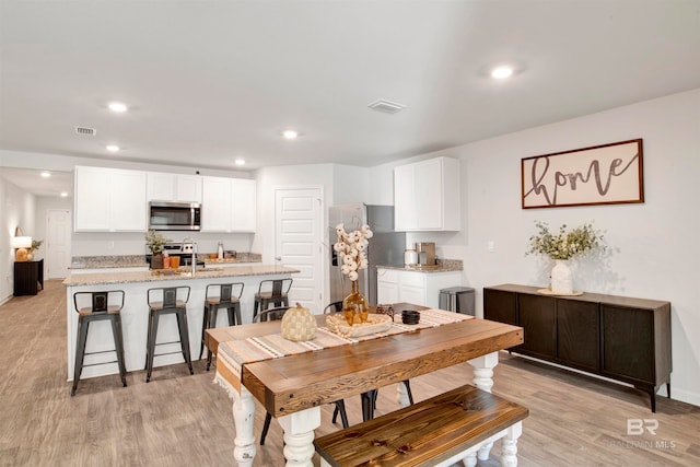 dining space with light hardwood / wood-style floors and sink