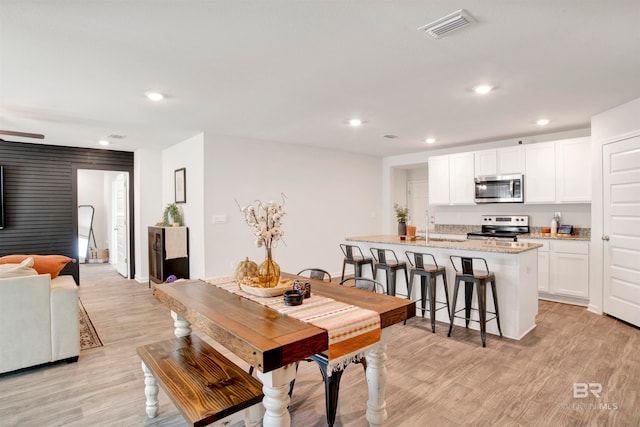 dining room featuring light hardwood / wood-style floors and ceiling fan