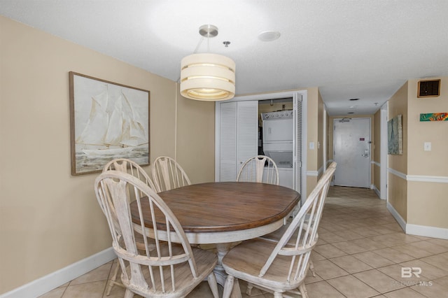 24132 Perdido Beach Blvd Unit 1063, Orange Beach, AL 36561 - dining area featuring baseboards, stacked washer and clothes dryer, and light tile patterned floors