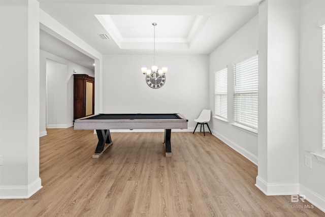 playroom with an inviting chandelier, light hardwood / wood-style floors, and a tray ceiling