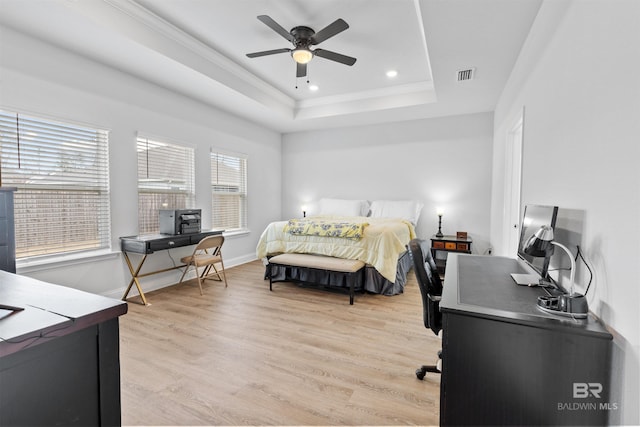 bedroom featuring a tray ceiling, light hardwood / wood-style flooring, ornamental molding, and ceiling fan