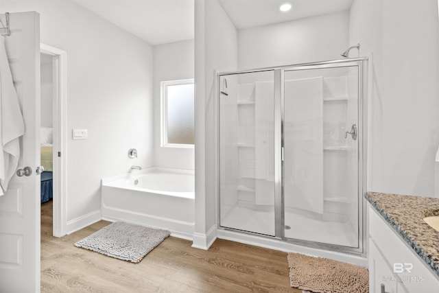 bathroom with vanity, wood-type flooring, and shower with separate bathtub