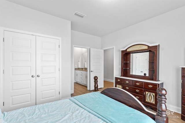 bedroom featuring connected bathroom, a closet, and light wood-type flooring