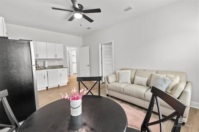 living room featuring ceiling fan and light hardwood / wood-style flooring