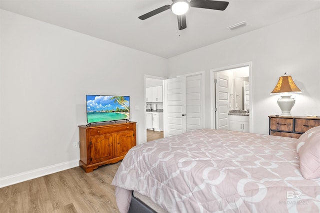 bedroom with ceiling fan, connected bathroom, and light hardwood / wood-style floors