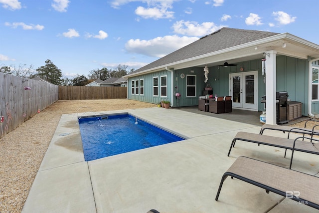 view of swimming pool featuring a patio, a grill, pool water feature, ceiling fan, and french doors