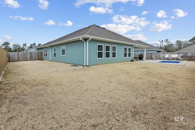 back of house featuring a fenced in pool, a patio area, and a lawn