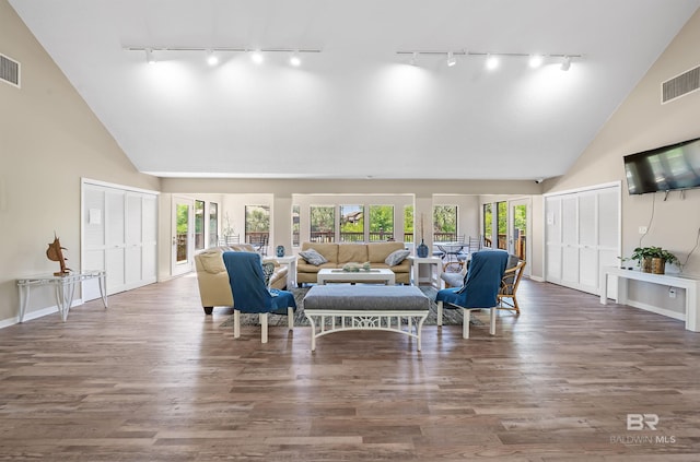 living room with dark wood-type flooring and high vaulted ceiling