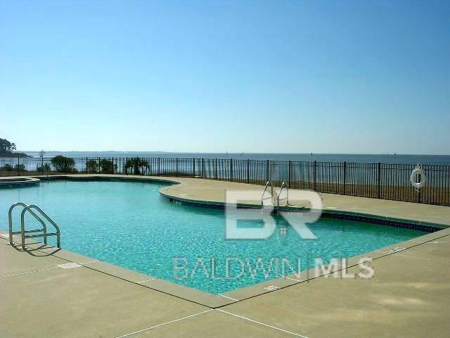 view of pool featuring a patio area and a water view