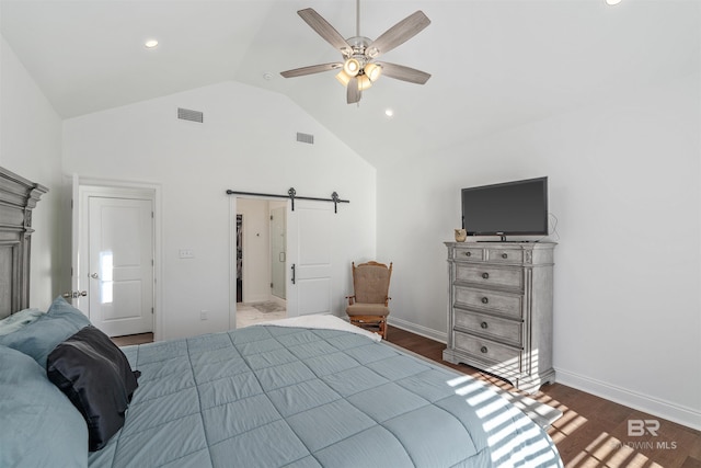 bedroom featuring a barn door, hardwood / wood-style floors, lofted ceiling, and ceiling fan