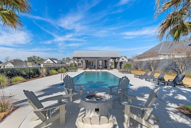 view of swimming pool featuring a patio and a fire pit