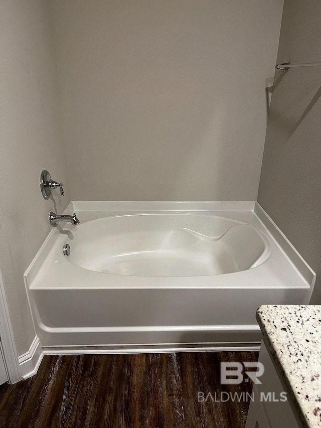 bathroom featuring vanity, wood-type flooring, and a bathing tub