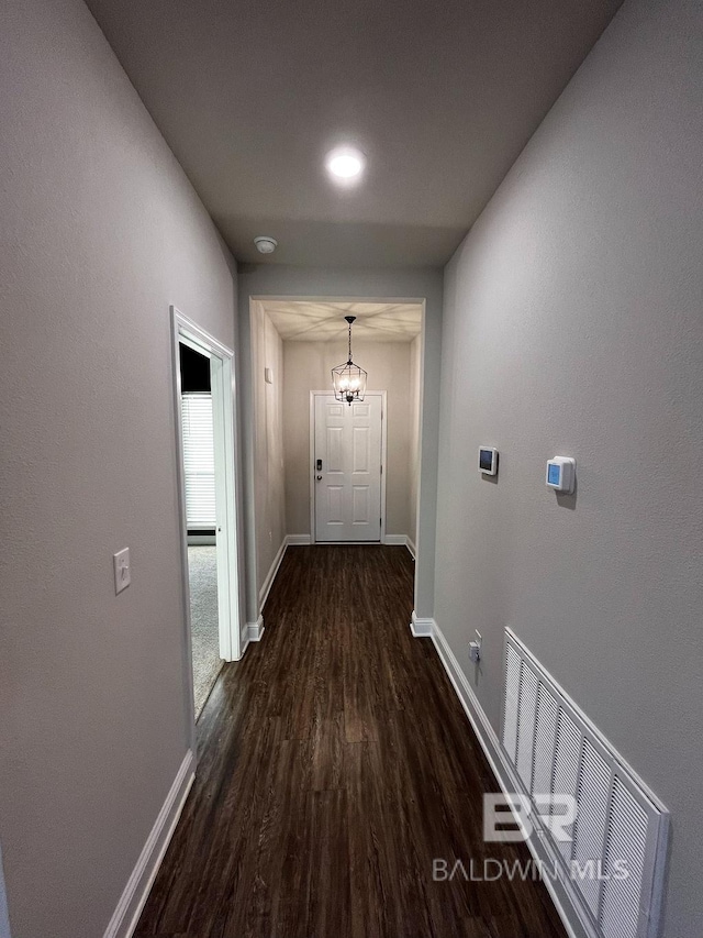 hall featuring dark hardwood / wood-style flooring and a notable chandelier