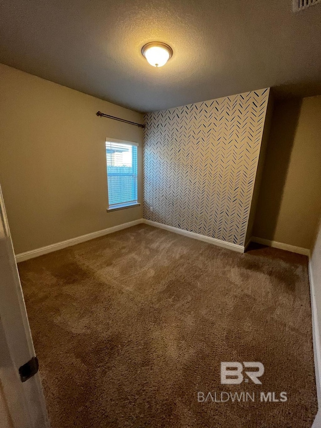 carpeted spare room featuring a textured ceiling