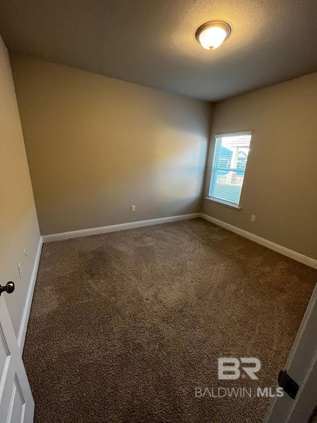 spare room featuring a textured ceiling and carpet floors