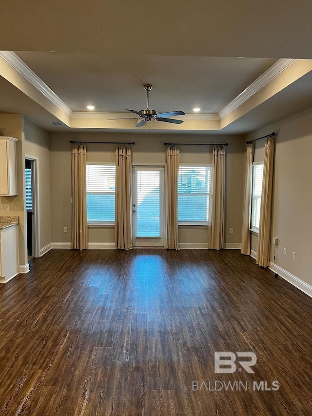 unfurnished living room featuring dark hardwood / wood-style flooring and a tray ceiling