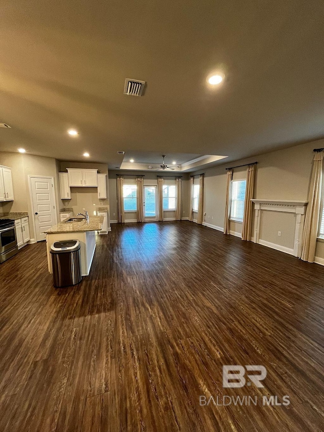 unfurnished living room with ceiling fan and dark hardwood / wood-style floors