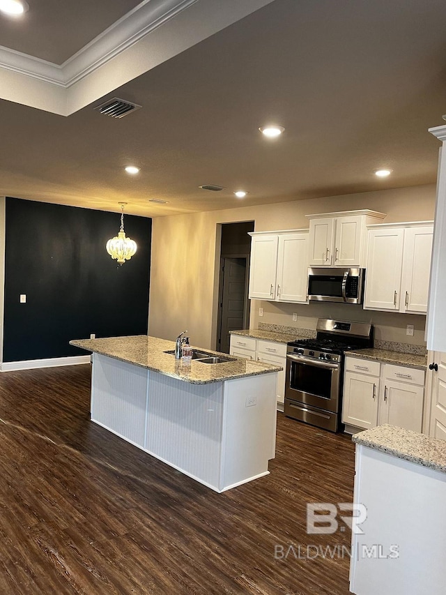 kitchen featuring dark hardwood / wood-style flooring, white cabinetry, appliances with stainless steel finishes, and a kitchen island with sink