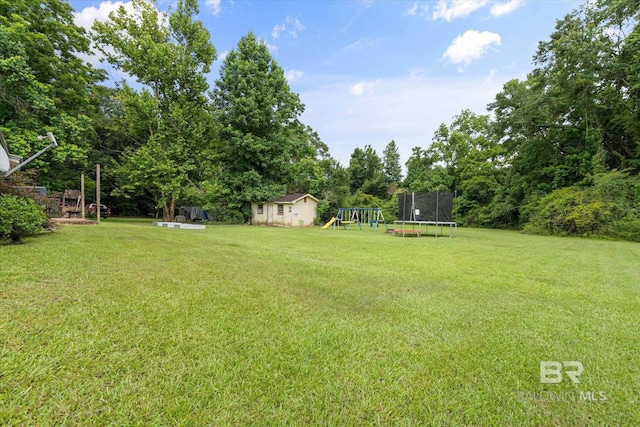 814 Taylor St, Bay Minette, AL 36507 - view of green lawn with a trampoline, a playground, a storage shed, and view of scattered trees