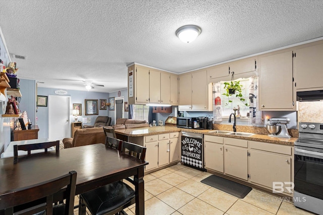 814 Taylor St, Bay Minette, AL 36507 - kitchen with appliances with stainless steel finishes, cream cabinets, under cabinet range hood, light countertops, and open floor plan
