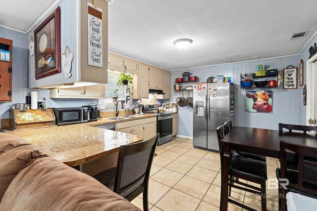 814 Taylor St, Bay Minette, AL 36507 - kitchen with stainless steel appliances, a textured ceiling, crown molding, light tile patterned floors, and under cabinet range hood