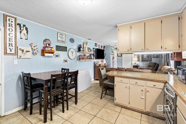 814 Taylor St, Bay Minette, AL 36507 - kitchen featuring cream cabinetry, a textured ceiling, light countertops, open floor plan, and light tile patterned flooring