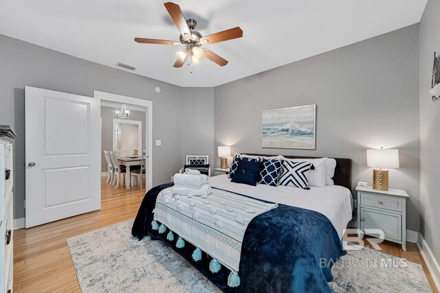 5781 State Highway 180 Unit 5003, Gulf Shores, AL 36542 - bedroom with ceiling fan with notable chandelier, baseboards, visible vents, and light wood-style floors