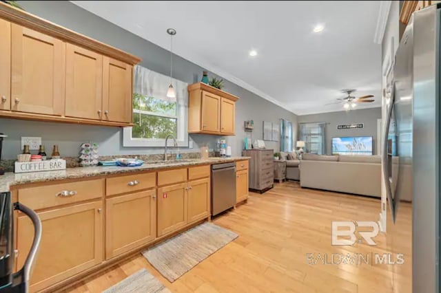 kitchen with appliances with stainless steel finishes, light brown cabinetry, light hardwood / wood-style flooring, sink, and decorative light fixtures