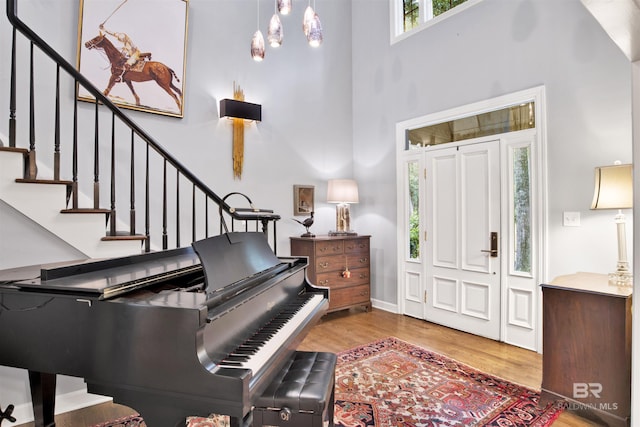 entryway with a towering ceiling and light hardwood / wood-style floors